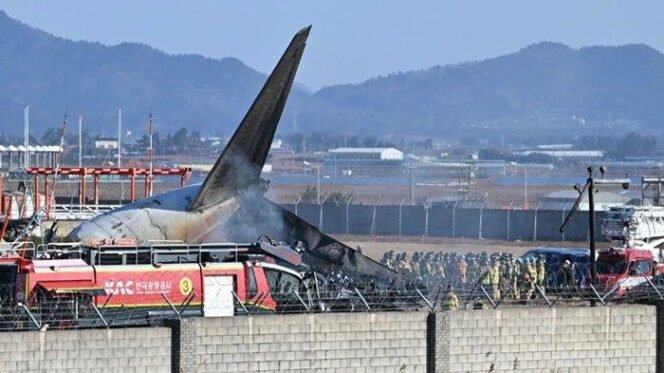 
					Petugas pemadam kebakaran berada di sekitar pesawat Jeju Air yang keluar dari landasan pacu di Bandara Internasional Muan, Muan, Provinsi Jeolla Selatan, Korea Selatan, Minggu (29/12/2024). 